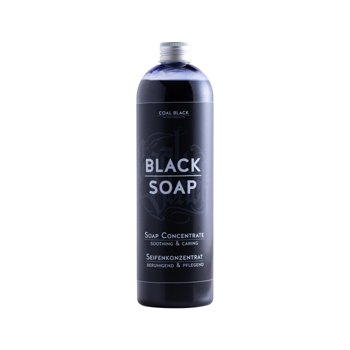 Un grand flacon noir de 500 ml étiqueté « Coal Black - Savon noir concentré » se tient debout sur fond blanc. L’étiquette, avec traductions en allemand, indique « Soap Concentrate - Soothing & Caring ».