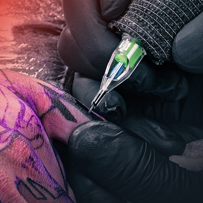 Un primer plano de un dedo siendo tatuado.